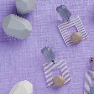  blue handcrafted earrings on purple background