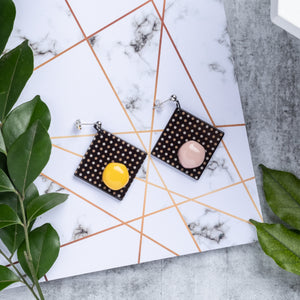 dark chocolate shape design with yellow and pink dots handcrafted earrings on marble background